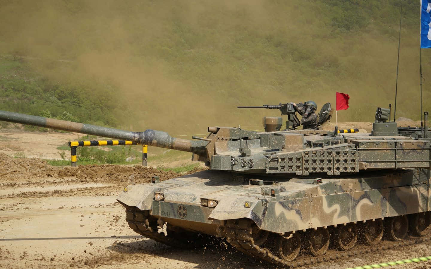An Army Tank Rolling Across a Field Wallpaper
