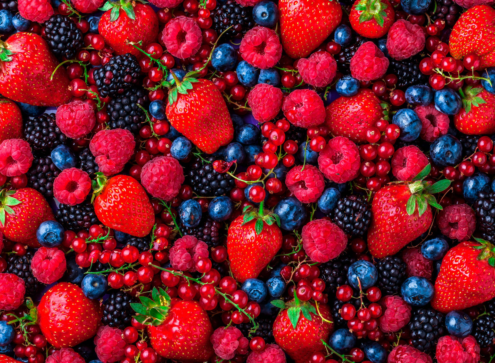 Scrumptious fresh raspberries amidst mixed berries Wallpaper