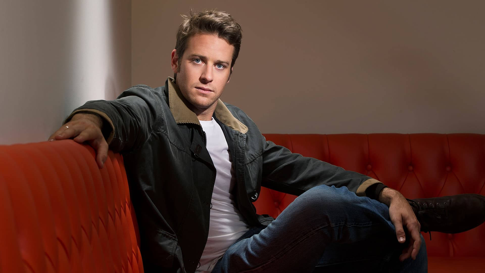 Armie Hammer At Orange Couch Wallpaper
