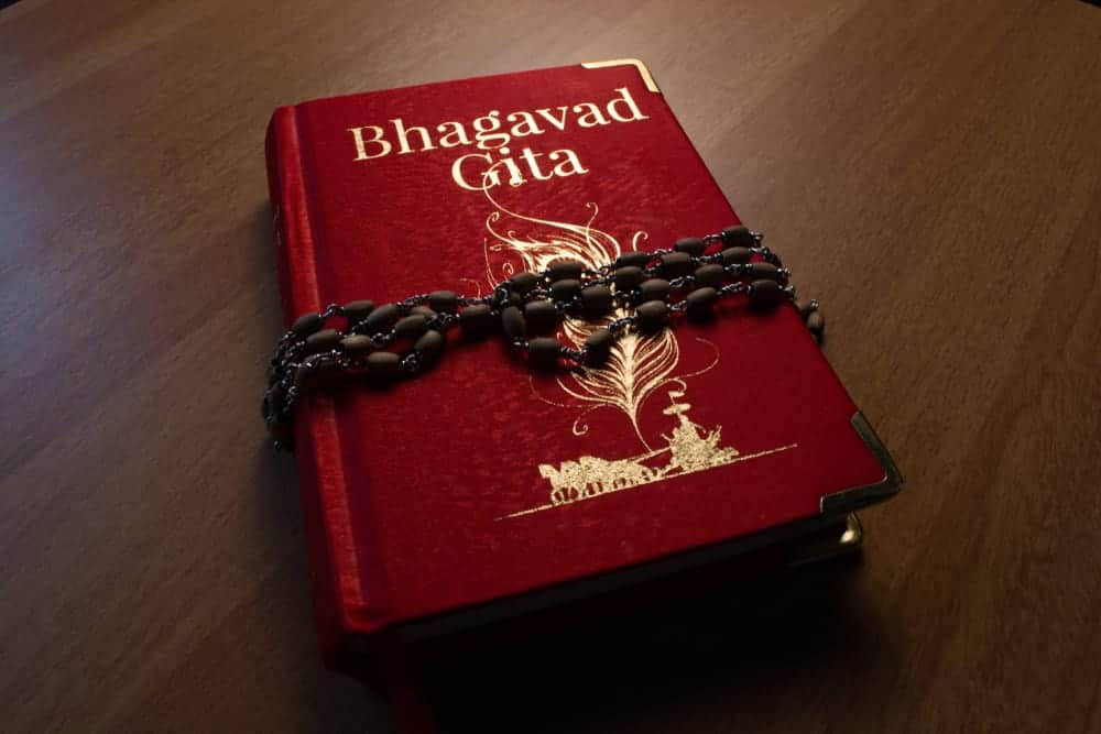Devotion through Bhagavad Gita and Japa Mala Beads Wallpaper