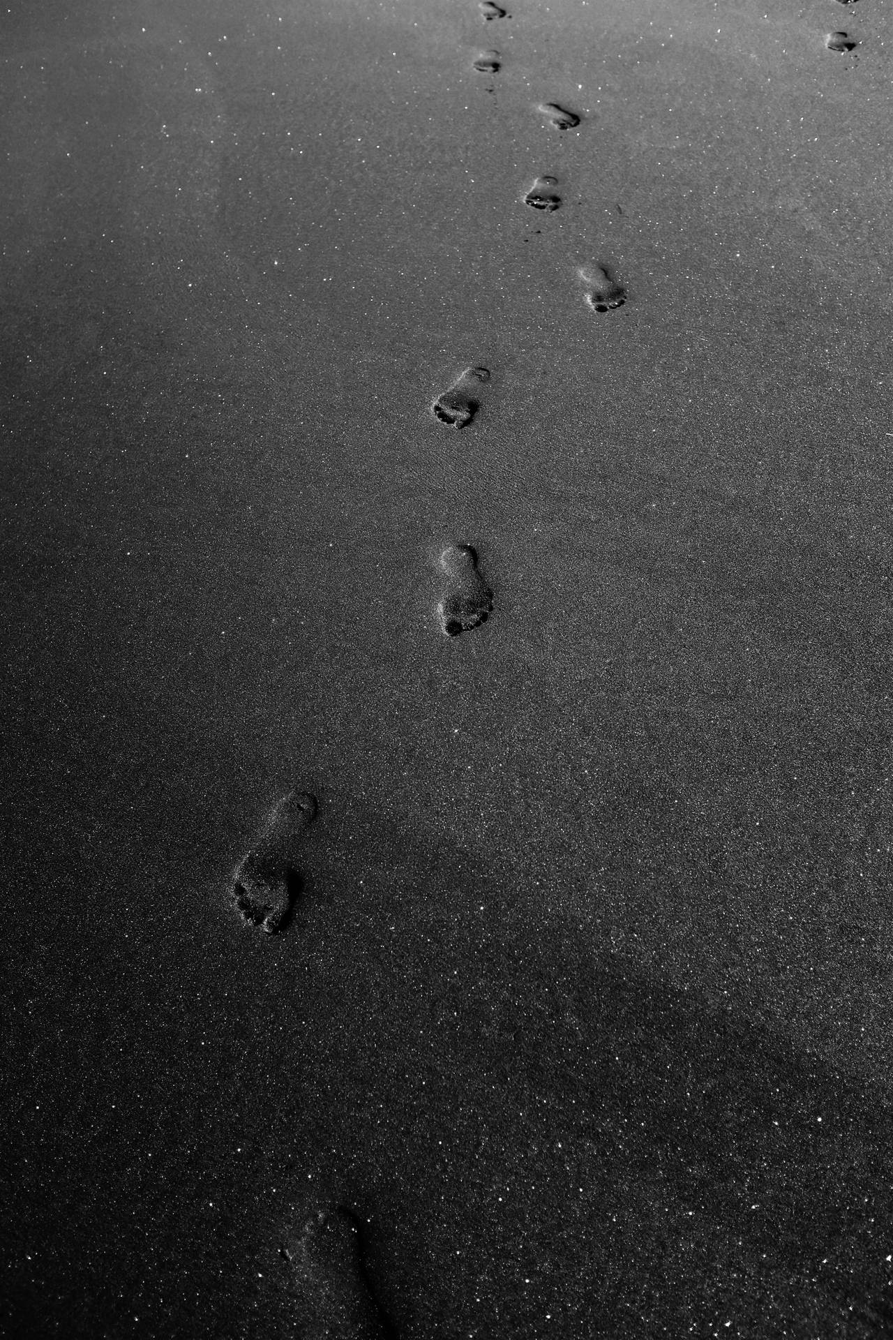 Mysterious Footprints on a Black Background Wallpaper