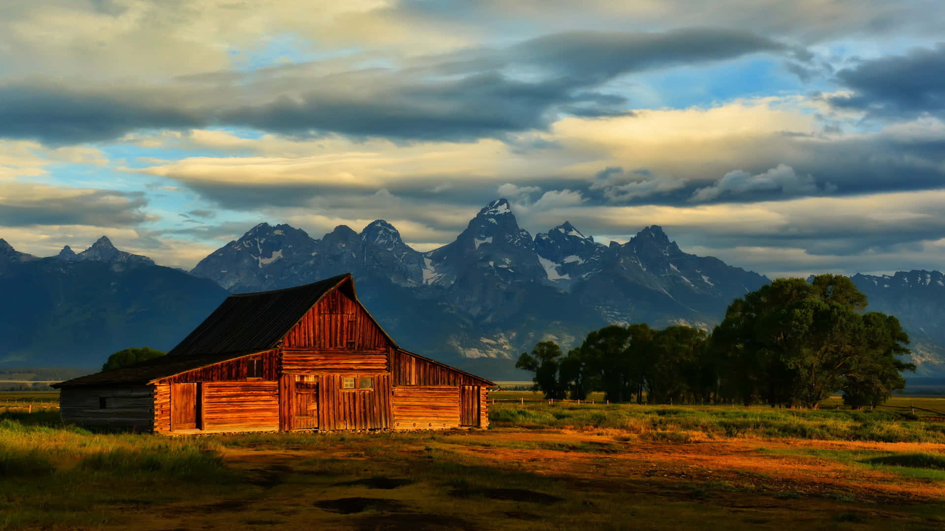 Cabin In The Field Overlooking Mountains Wallpaper