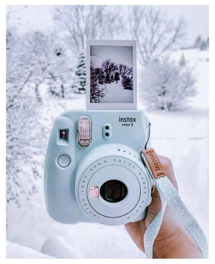 A Person Holding A Camera In The Snow