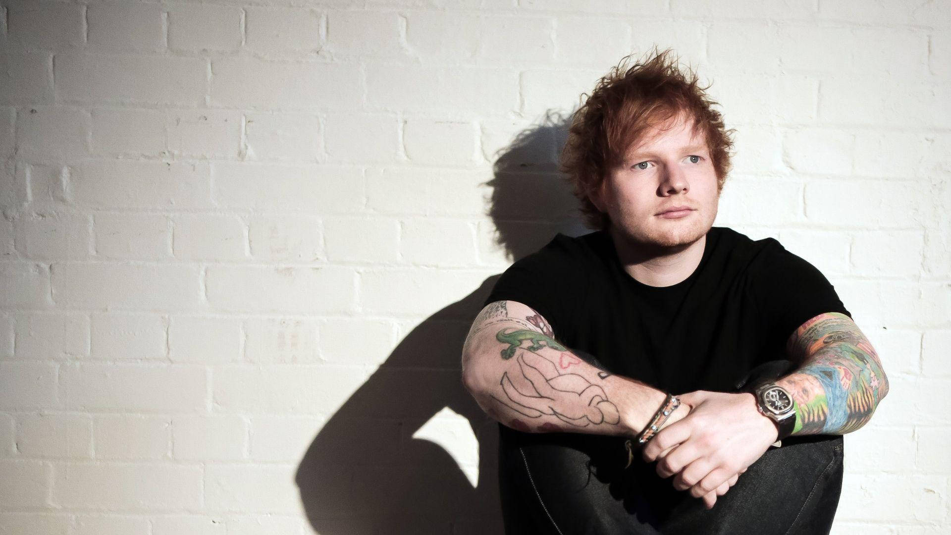 Singer-songwriter Ed Sheeran posing in a charming fashion Wallpaper