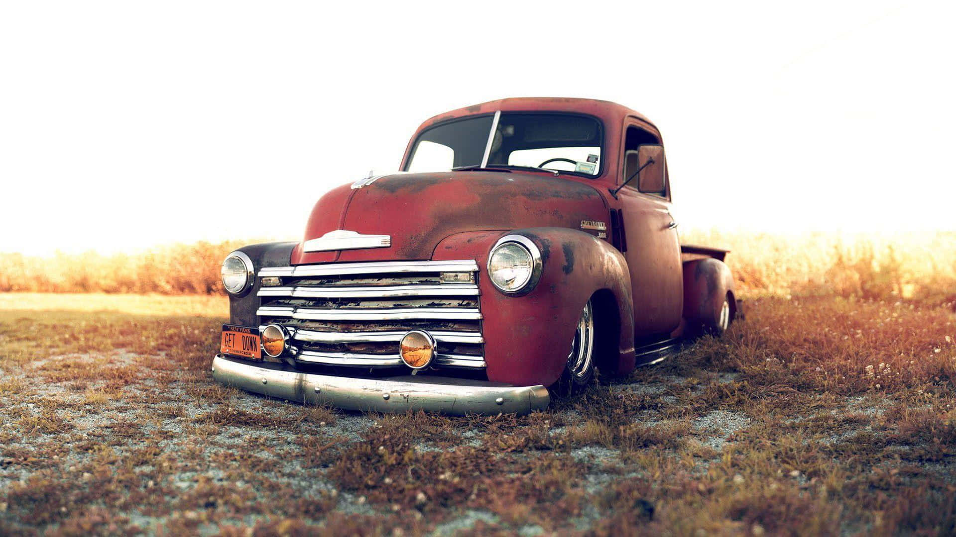 A Red Truck Is Parked In A Field Wallpaper