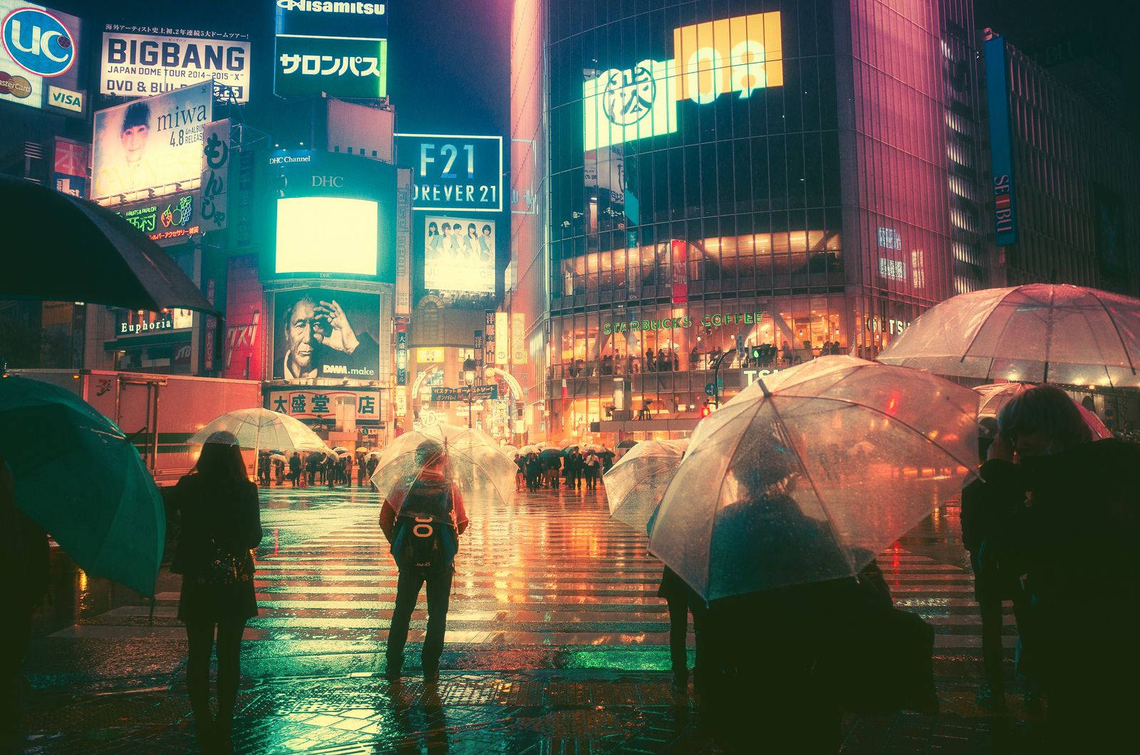 "Cars zooming by as pedestrians cross at the iconic Shibuya Crossing in Tokyo" Wallpaper
