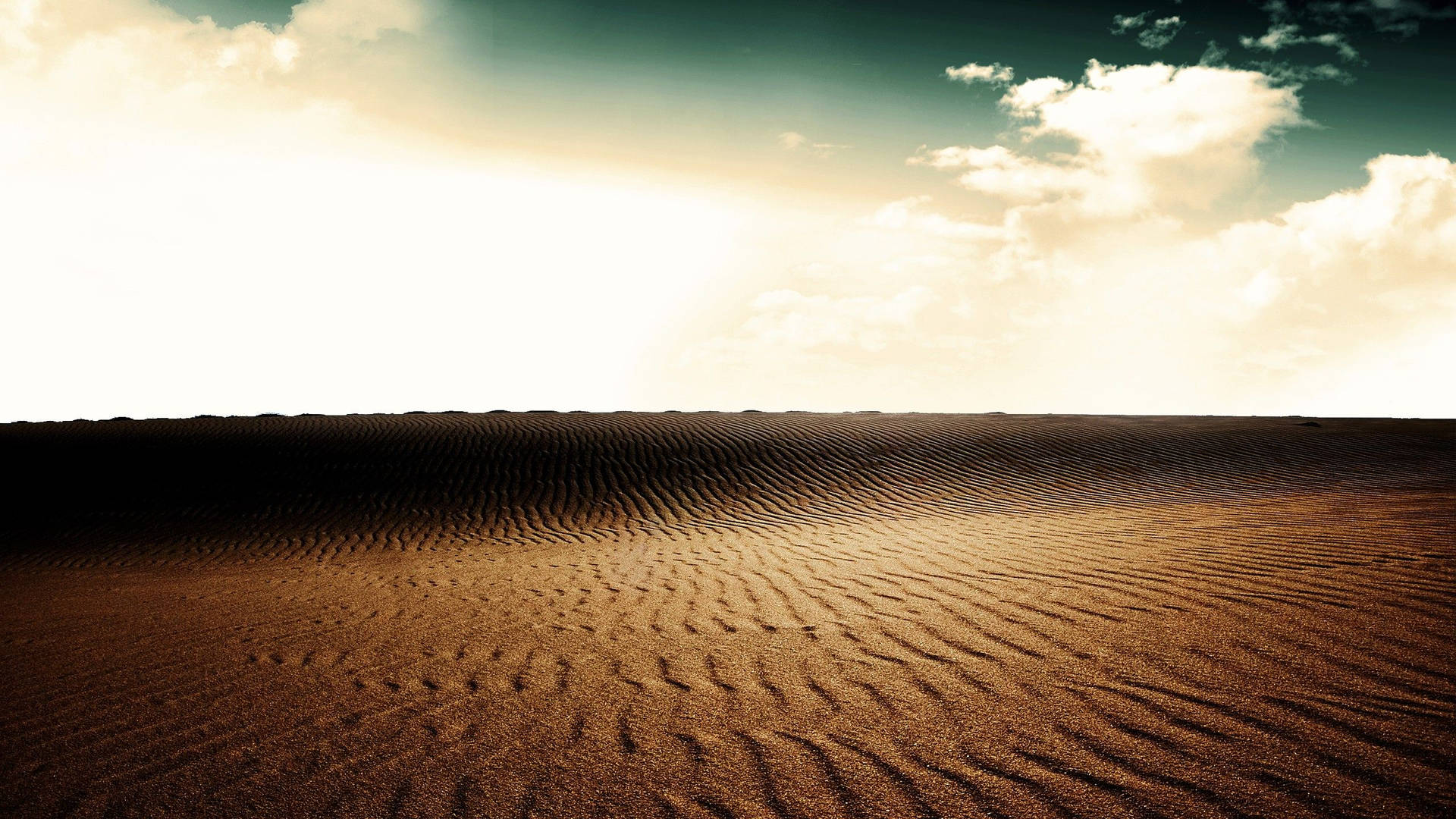 "A peaceful desert landscape with stripes of sand and a cloudy sky" Wallpaper