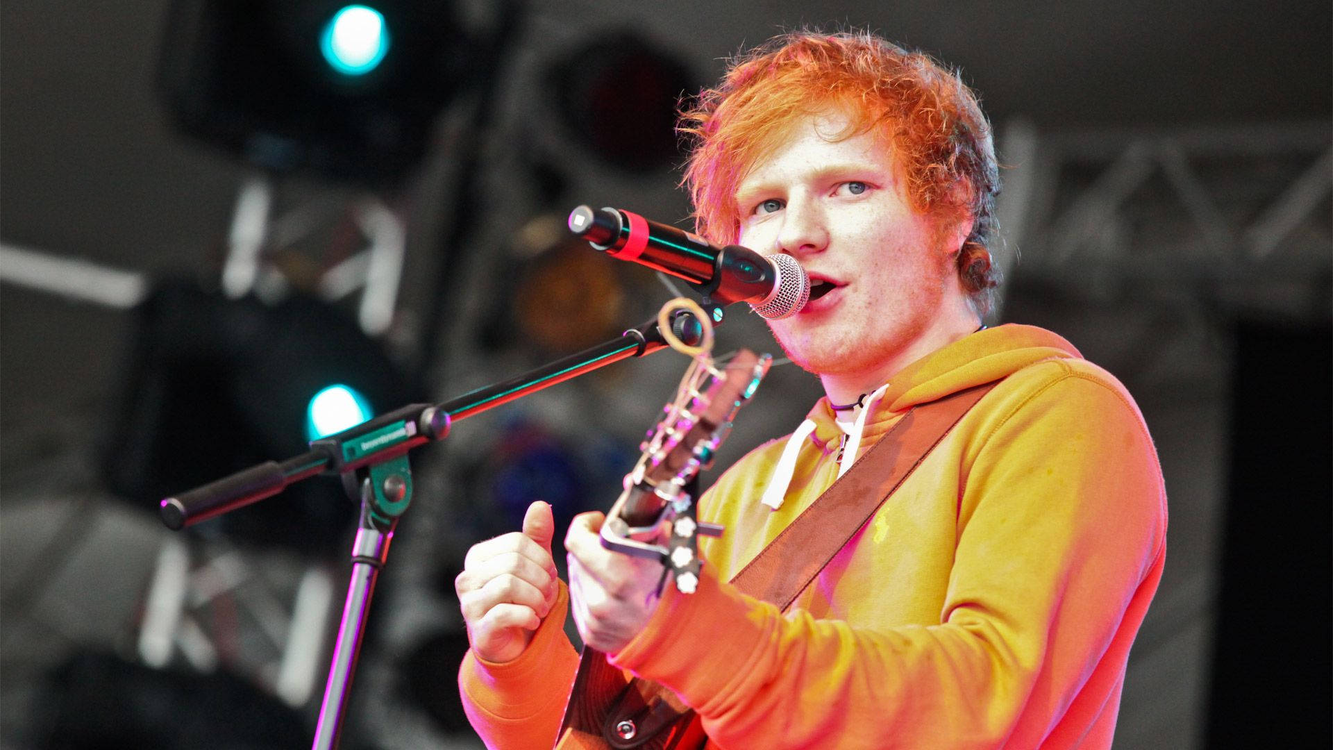 Ed Sheeran rocking in an orange jacket Wallpaper
