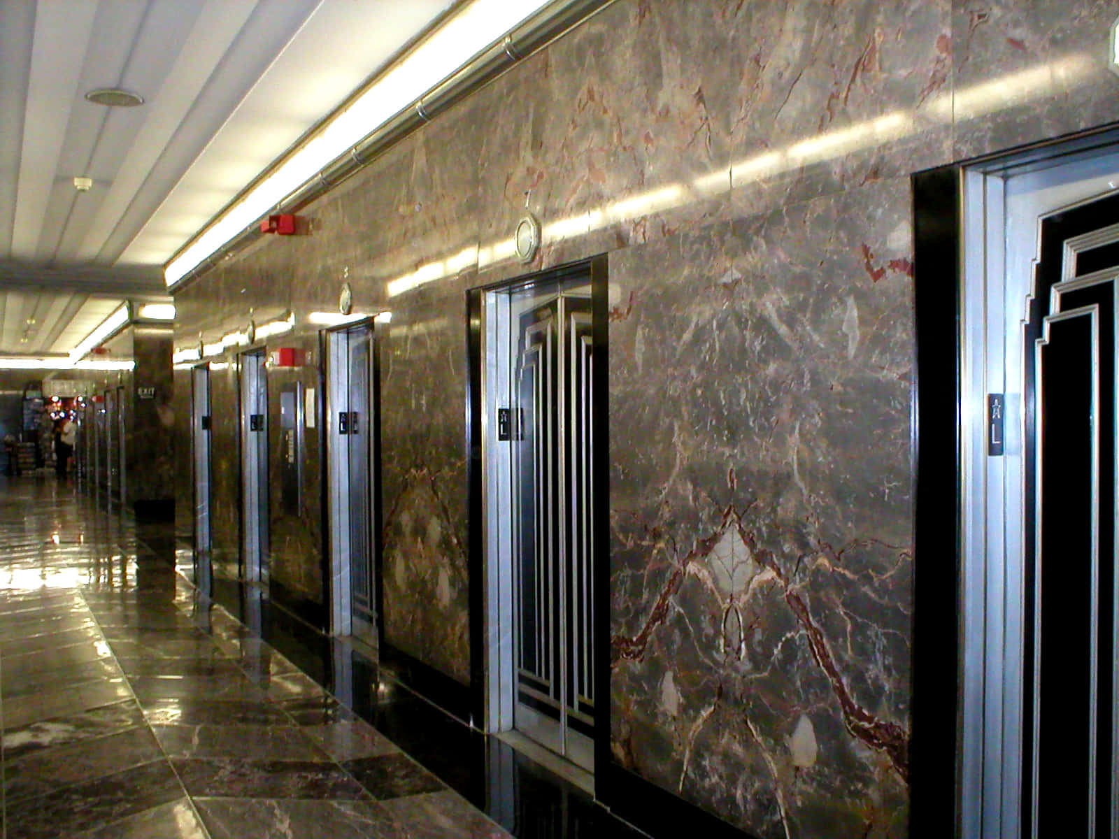 A Long Hallway With Many Elevators