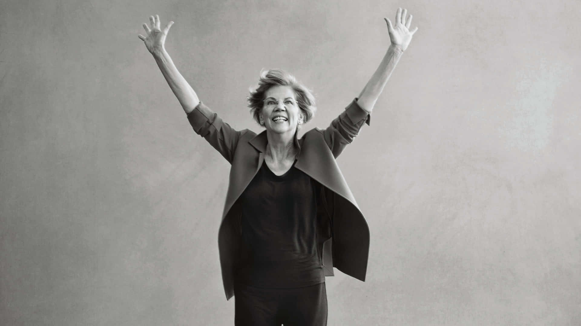 Elizabeth Warren raising her arms in a powerful stance Wallpaper