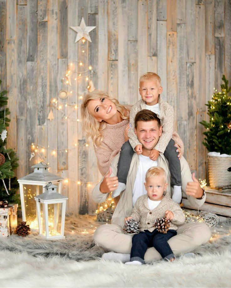 A Family Poses For A Christmas Photo In Front Of A Christmas Tree