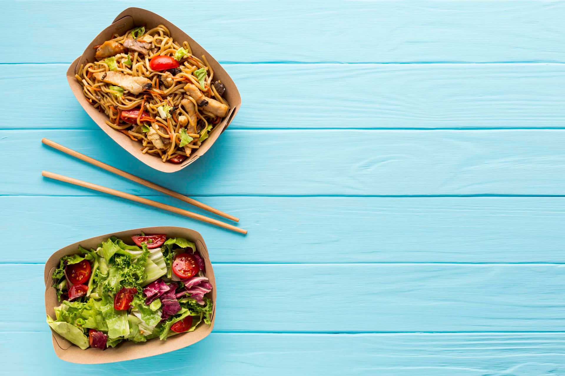 Two Bowls Of Salad And Noodles On A Blue Wooden Table