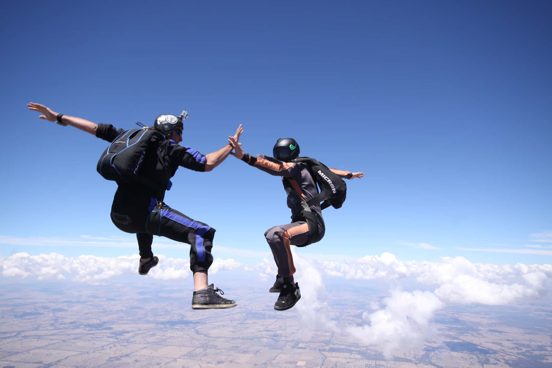 Caption: High-Five in the Sky - Skydiving Adventure Wallpaper