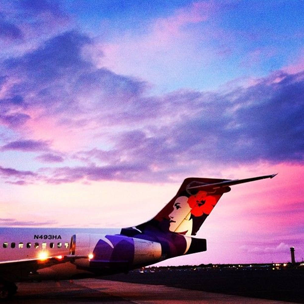 Hawaiian Airlines Jet Gliding Against the Purple Twilight Wallpaper