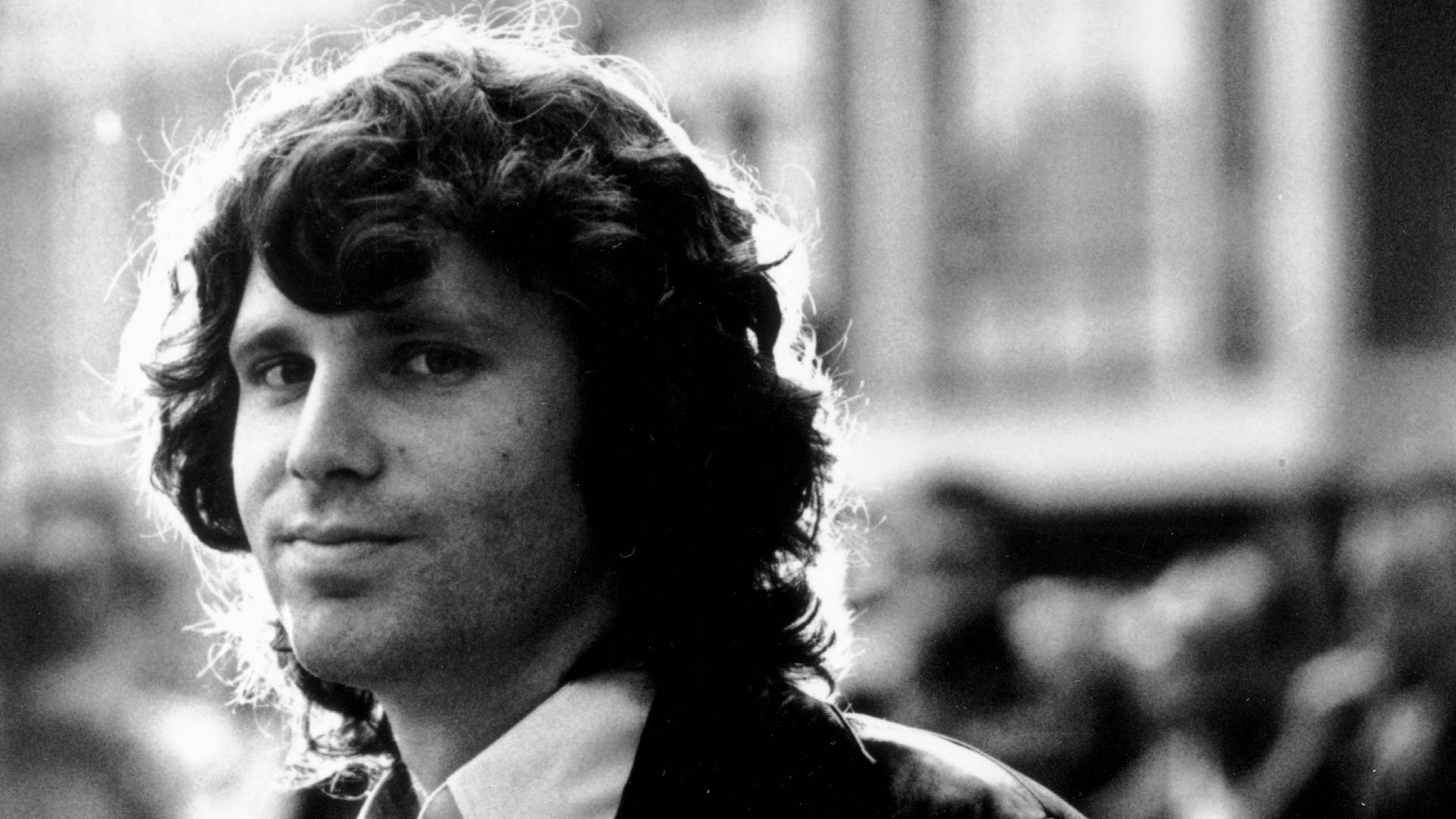Legendary Jim Morrison with a Charming Smile Wallpaper