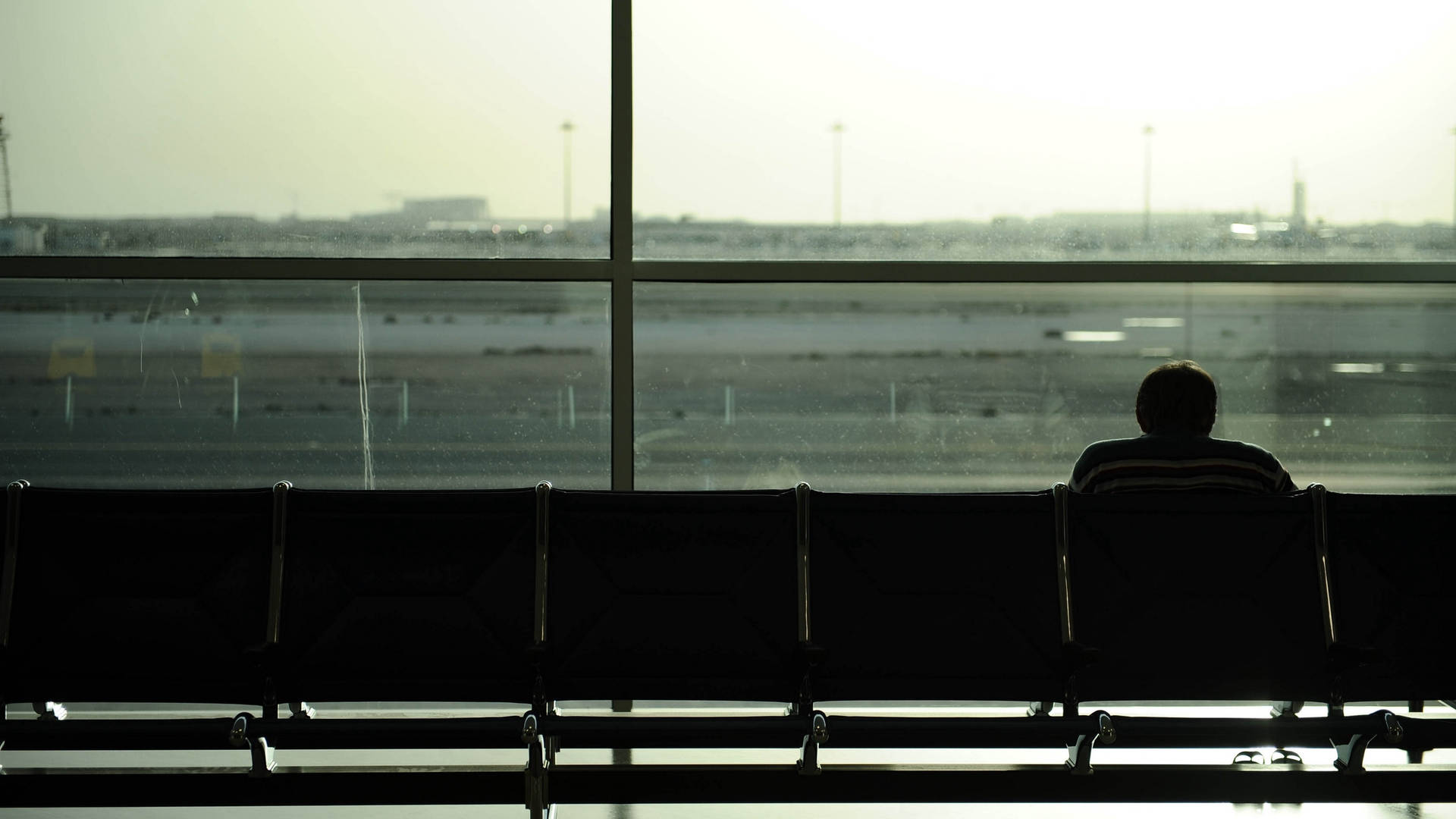 Solitary Man Waiting at Airport Lounge Wallpaper