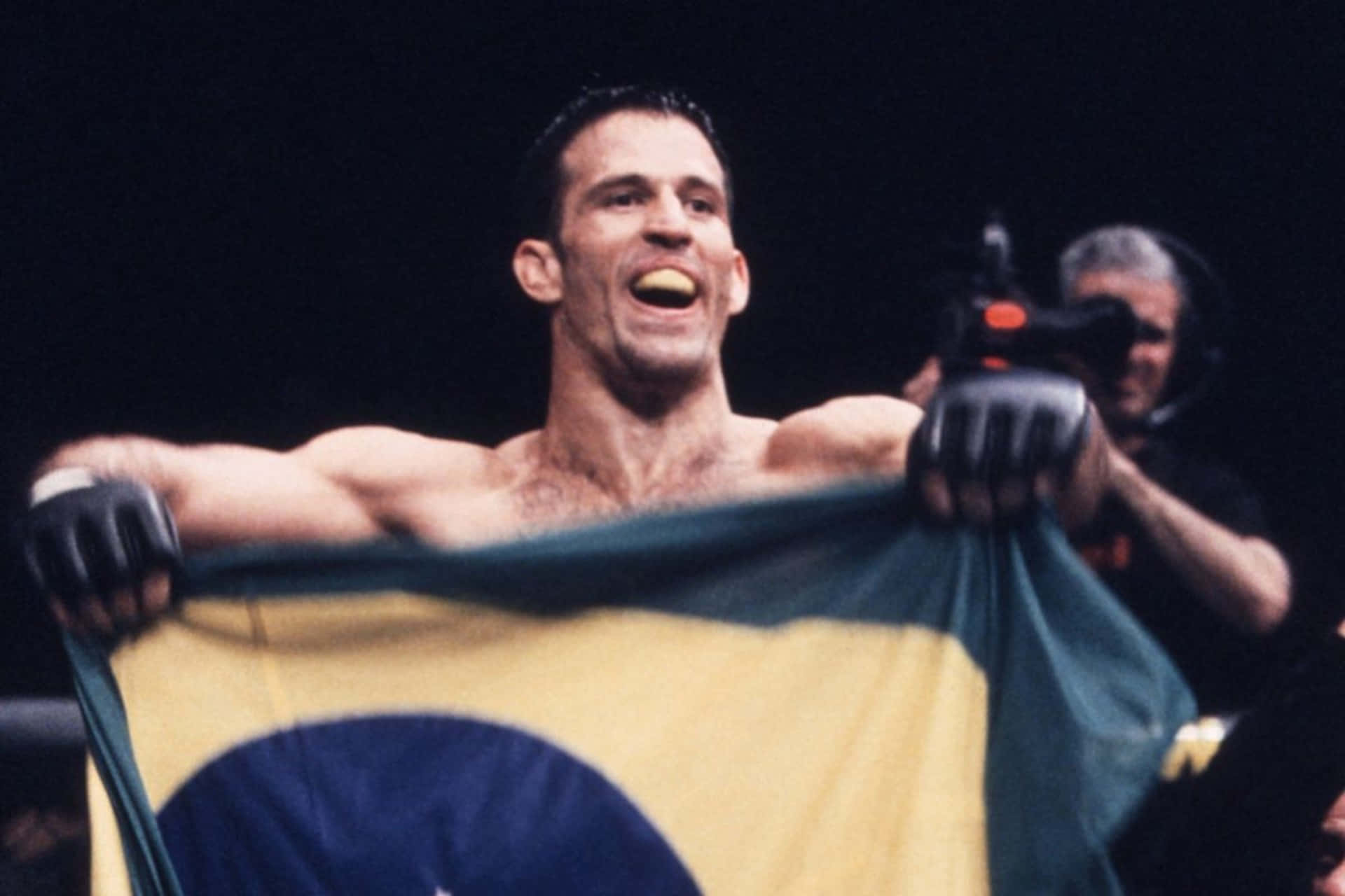 Murilo Bustamante triumphantly waving the Brazilian flag. Wallpaper