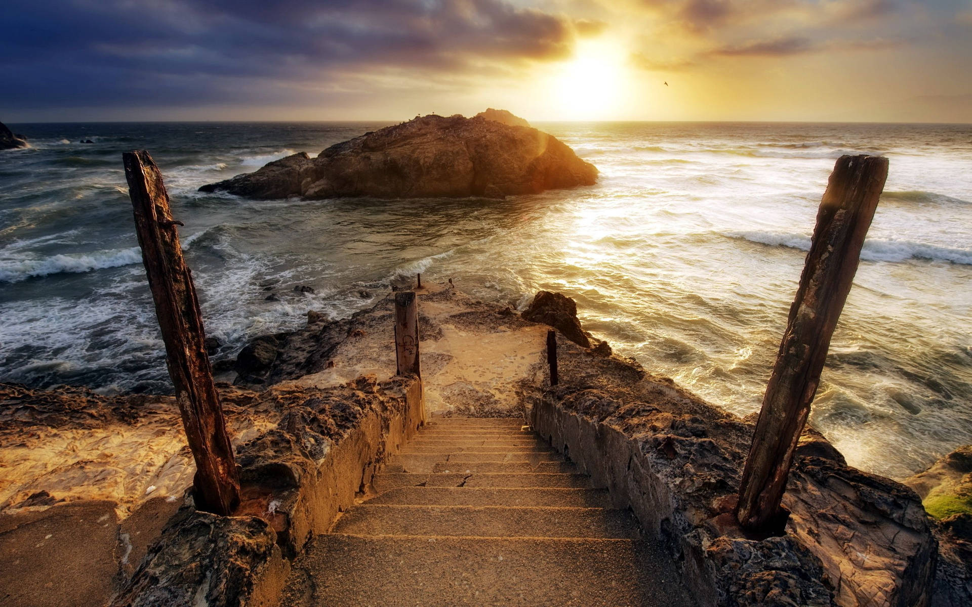 A beautiful sunset, with a set of stairs leading down to the water. Wallpaper