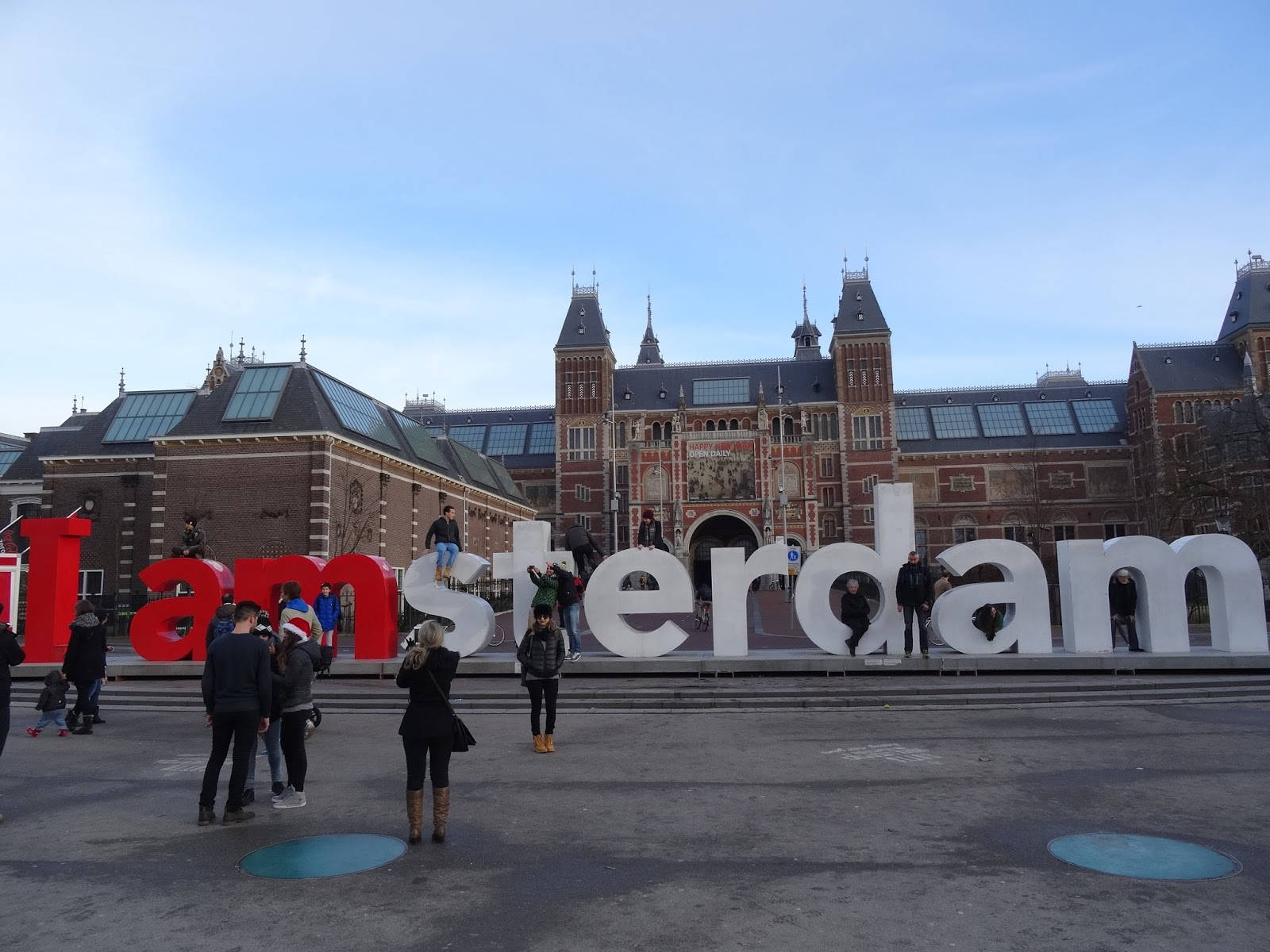 Tourists posing with the iconic Amsterdam sign in front of the prestigious Rijksmuseum. Wallpaper