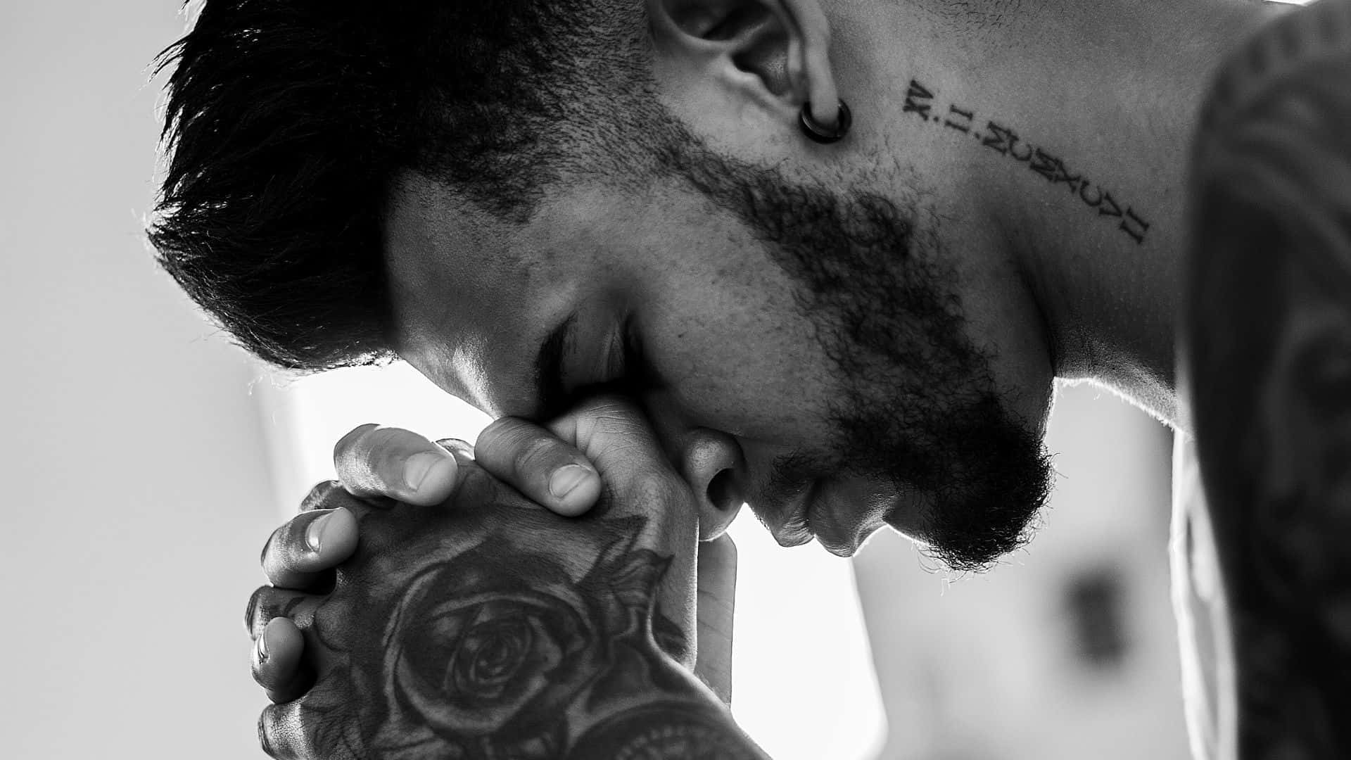 Spiritual Ink - Closeup shot of a man with hand tattoo meditating or praying. Wallpaper