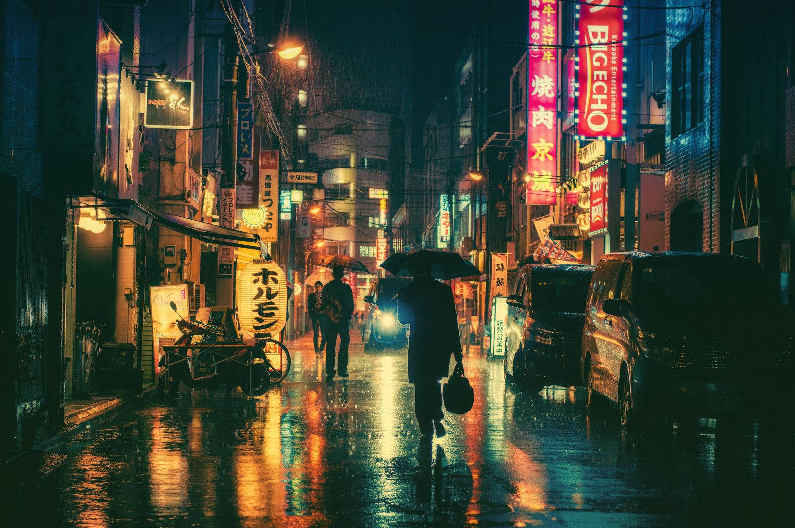 Night time in Tokyo, illuminated by neon signs on a rainy night Wallpaper