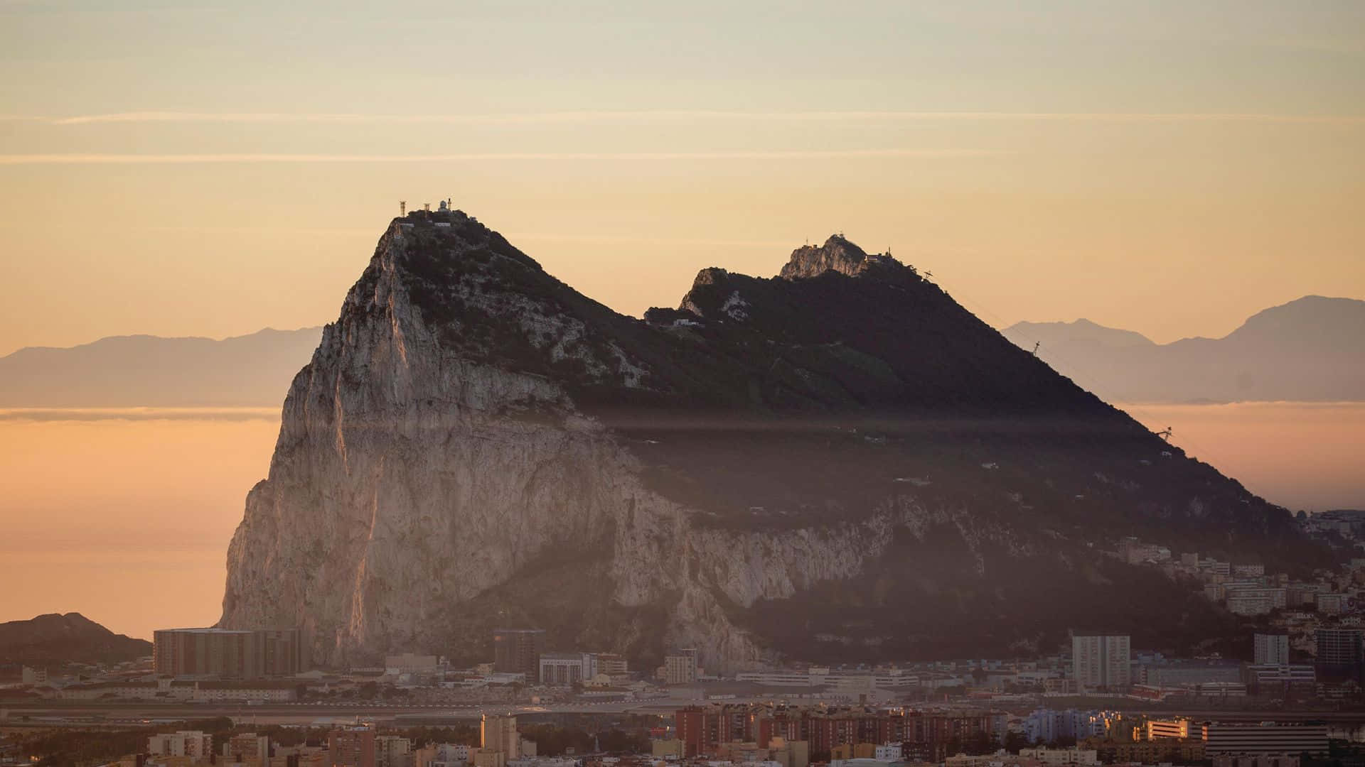 Caption: Majestic Sunset Over Rock of Gibraltar Wallpaper