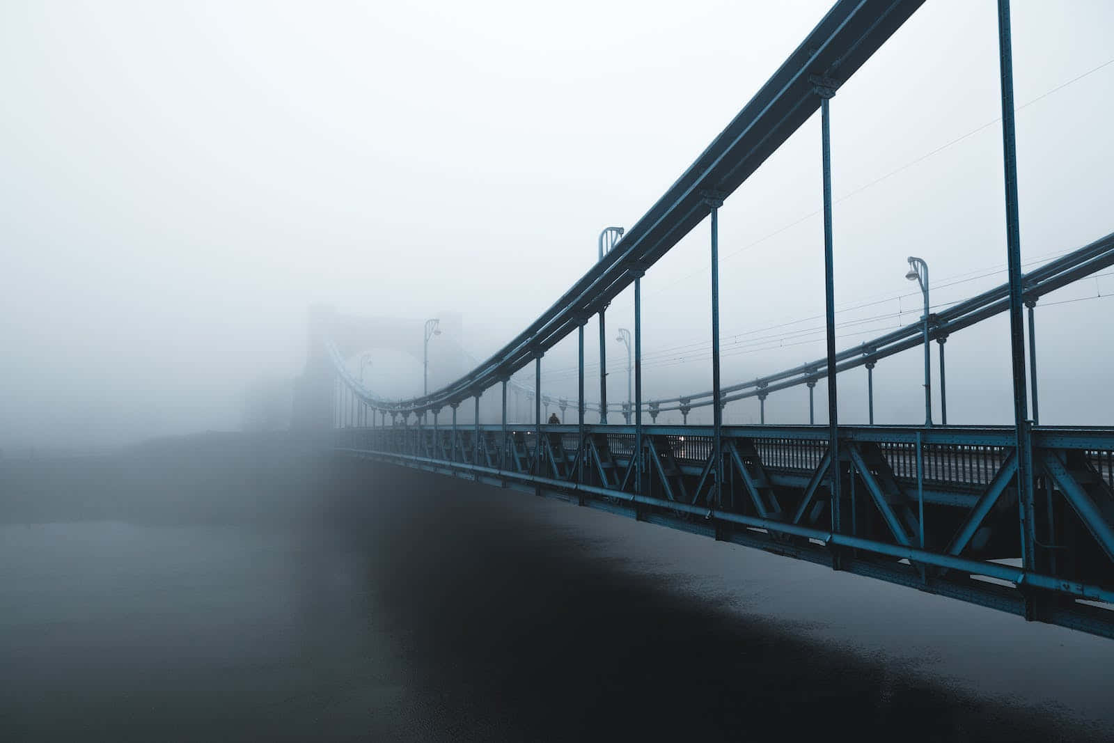 A Bridge In The Fog With A Blue Railing Wallpaper