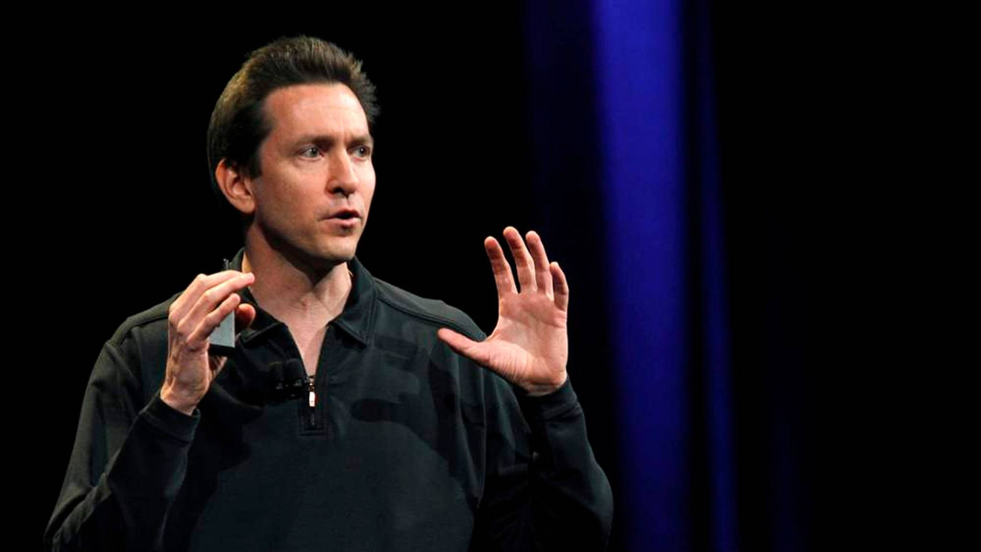 Scott Forstall passionately expounding a point with animated hand gestures Wallpaper