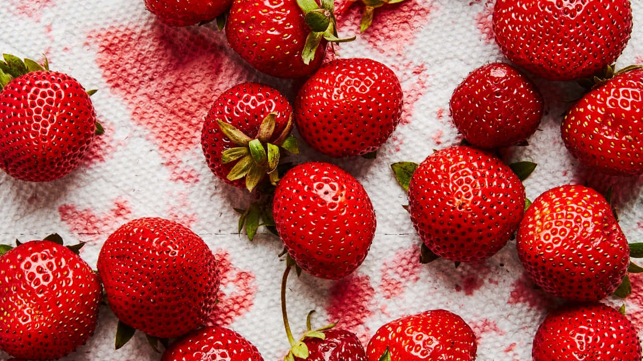 Vibrant Red Stains Of Strawberries Background