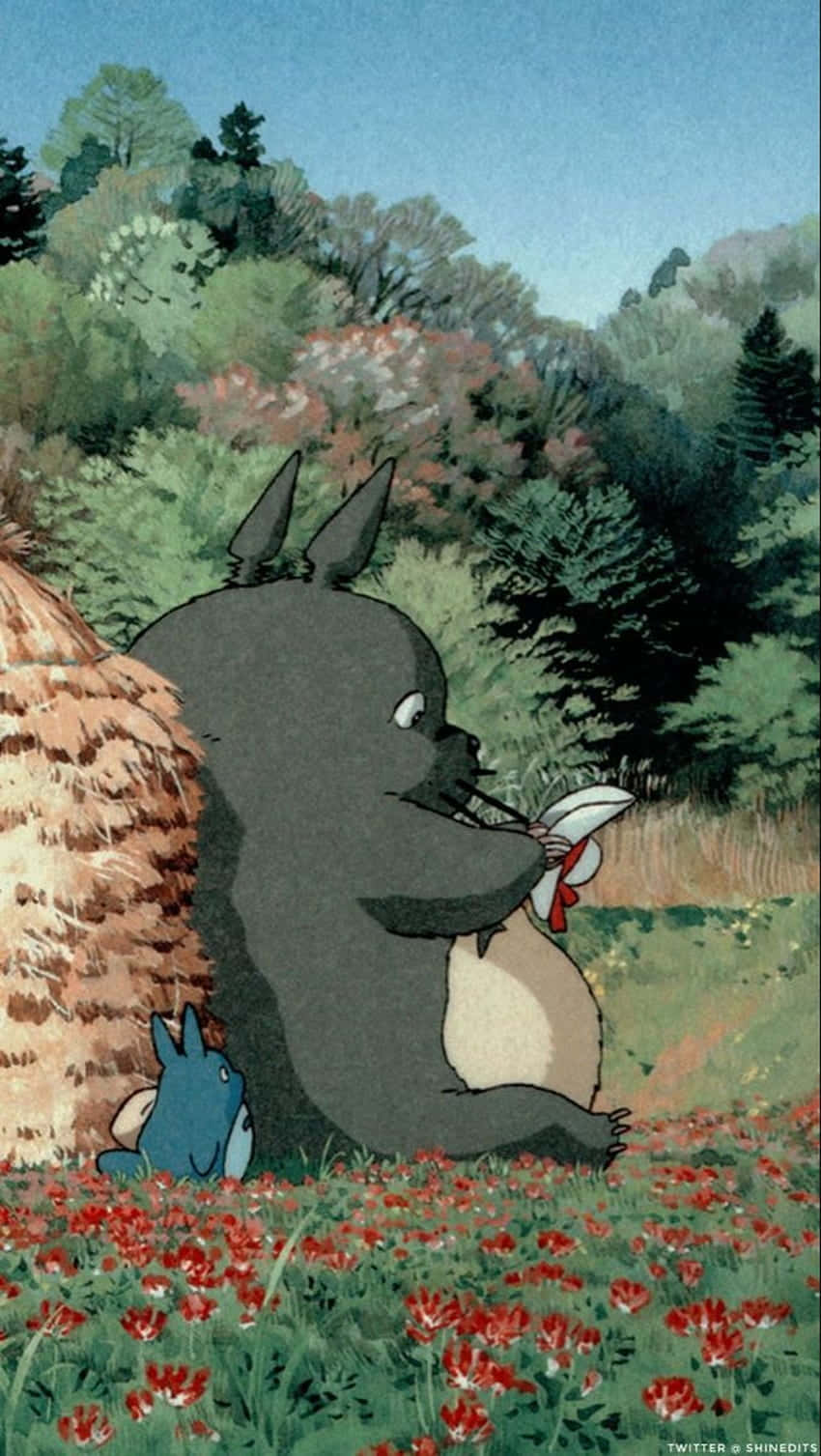a totoro and a hay bale sitting in a field Wallpaper