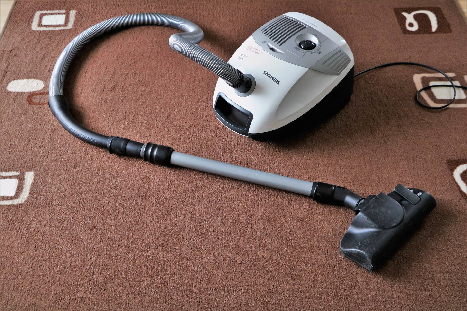 Vacuum Cleaner On Brown Rug Wallpaper
